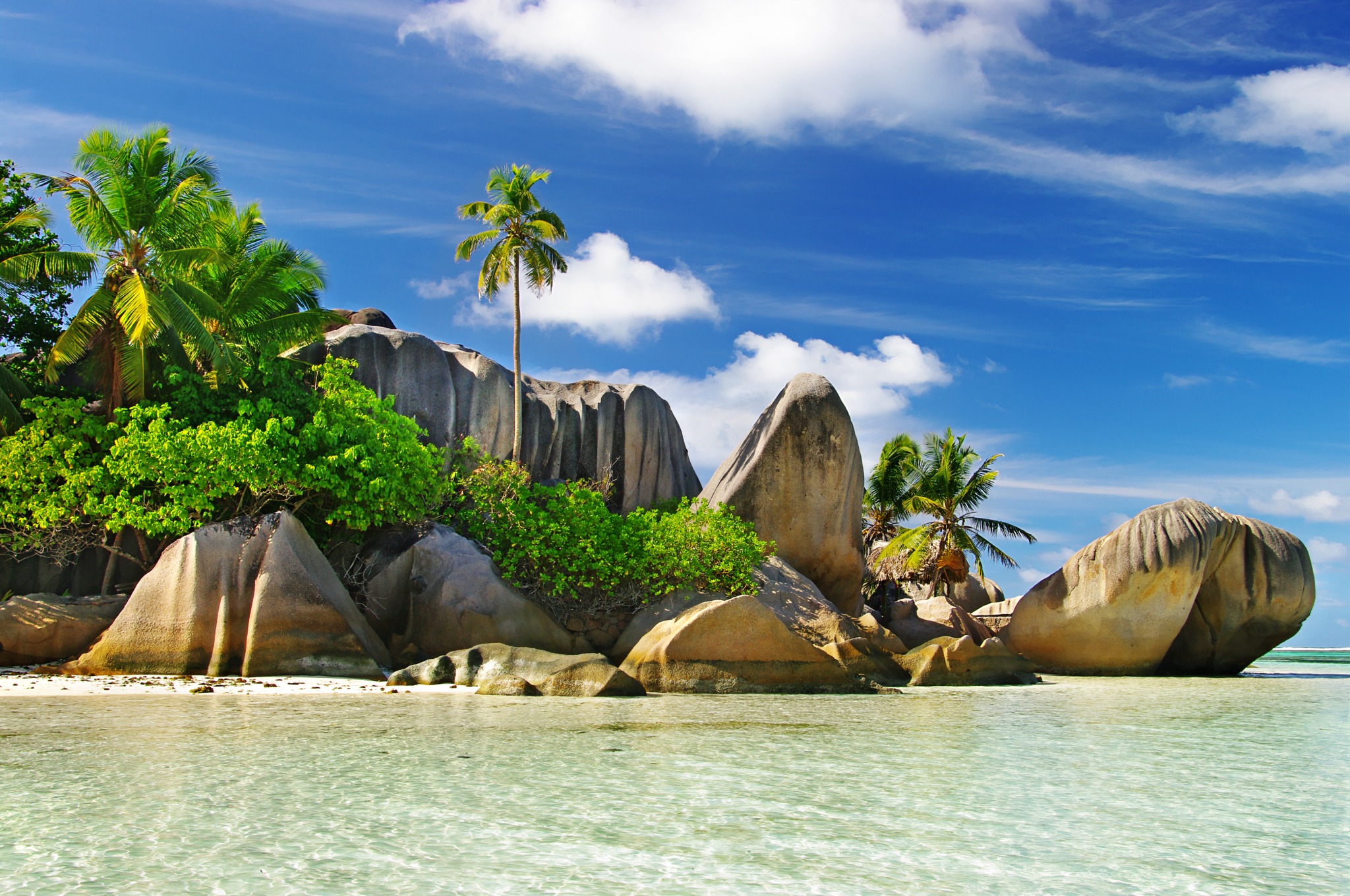 Playa de Seychelles con formaciones de granito, palmeras y agua turquesa